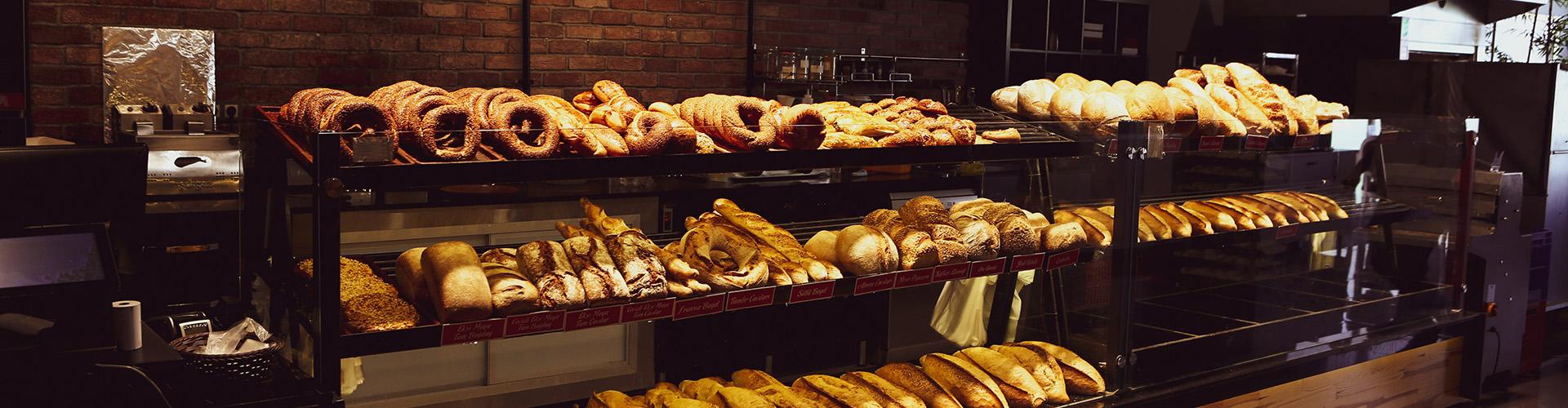 Des baguettes et autres viennoiseries posées sur une étale d'une boulangerie.